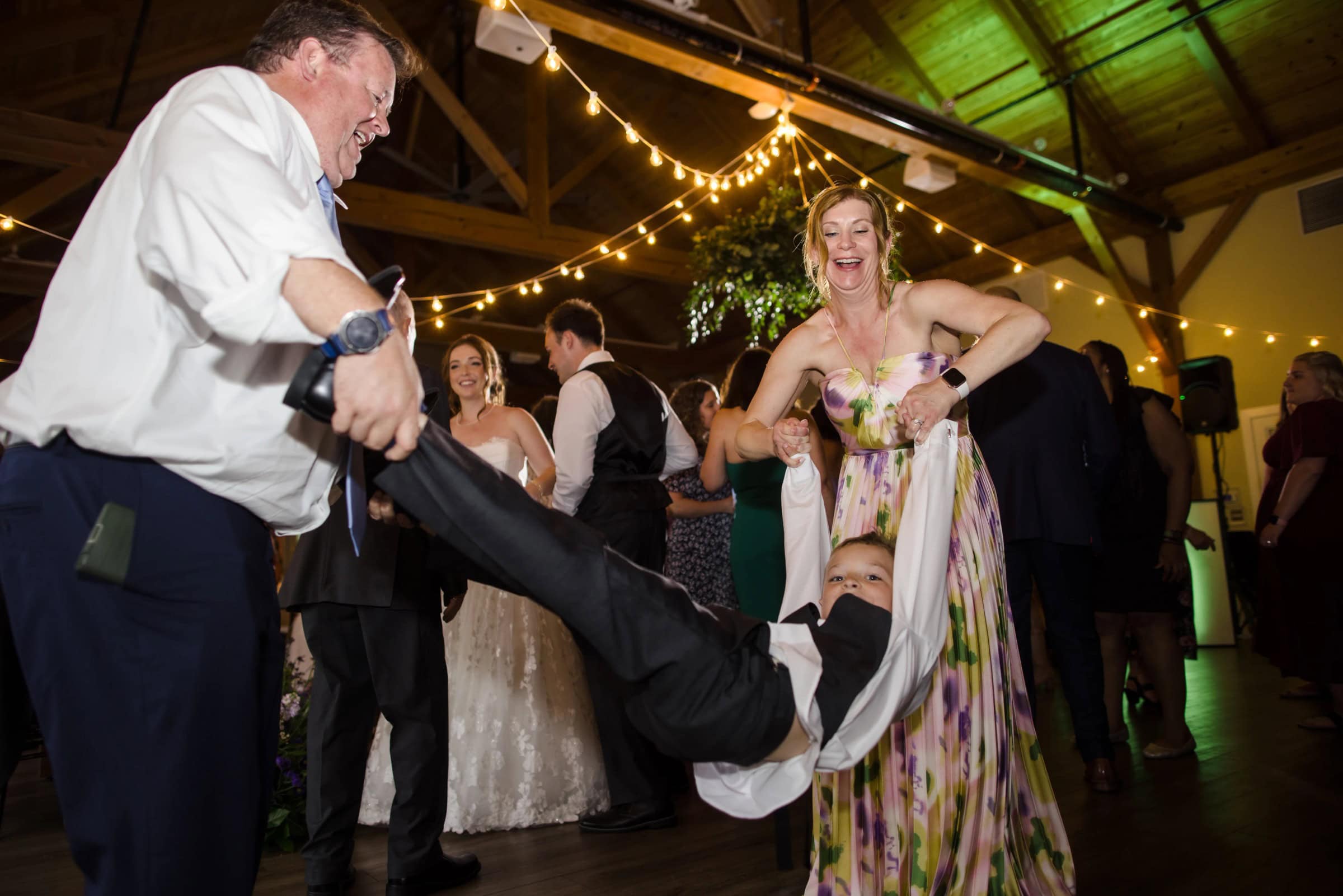 Man and woman dancing together at an indoor reception, her leg lifted playfully as guests watch. — Wedding at Glasbern Inn, Fogelsville, PA
