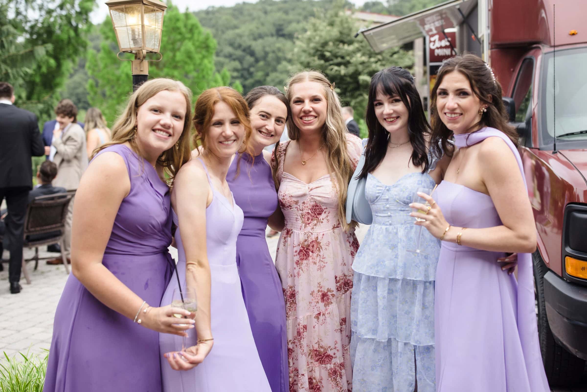 Six women in bridesmaid dresses posing together at an outdoor wedding venue, smiling at the camera. — Wedding at Glasbern Inn, Fogelsville, PA