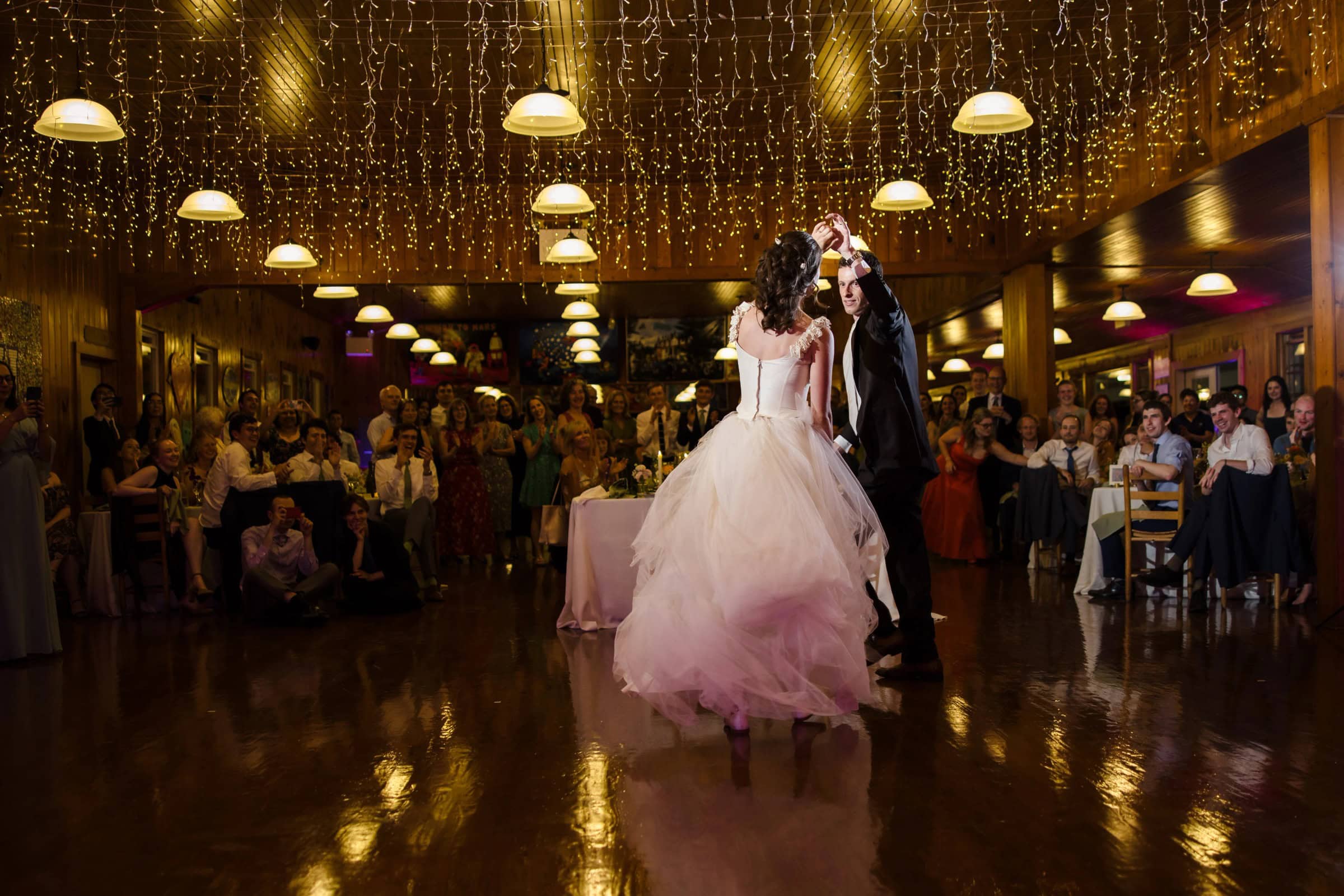 Bride and groom dancing together on the reception floor while guests watch from around the dance floor. — Wedding at Tyler Hill Camp, Tyler Hill, PA