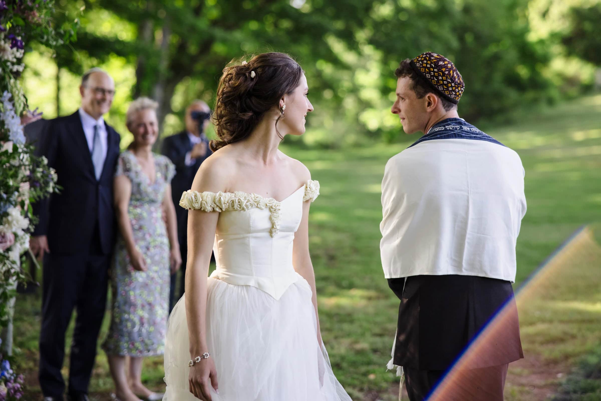 Bride and groom exchange vows at the altar during their outdoor wedding ceremony. — Wedding at Tyler Hill Camp, Tyler Hill, PA