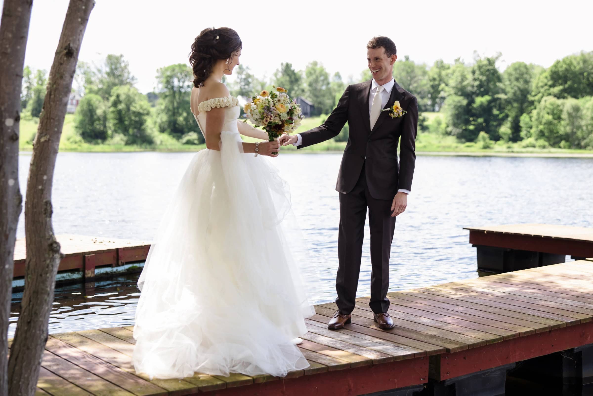 Bride and groom exchanging vows or sharing a moment on a wooden dock by the water. — Wedding at Tyler Hill Camp, Tyler Hill, PA