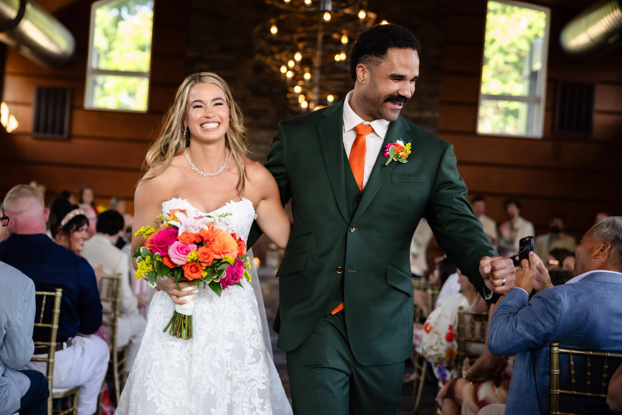 Bride and groom walk together down the aisle as guests watch and applaud during their wedding ceremony recessional. &mdash; Wedding at Landmark Tavern at Stonehouse, Warren, NJ