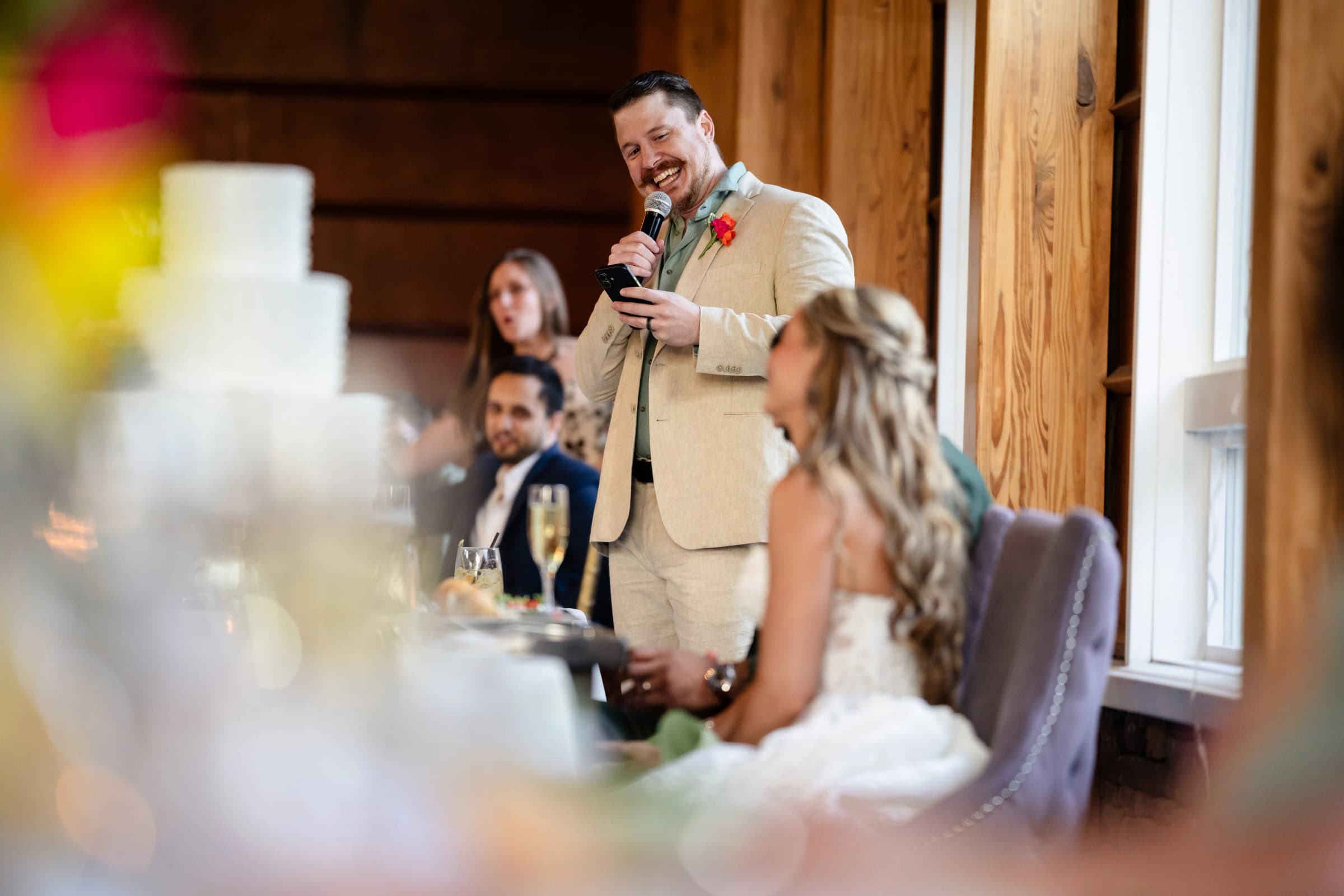 Groom giving a speech at the reception while guests listen and smile. &mdash; Wedding at Landmark Tavern at Stonehouse, Warren, NJ