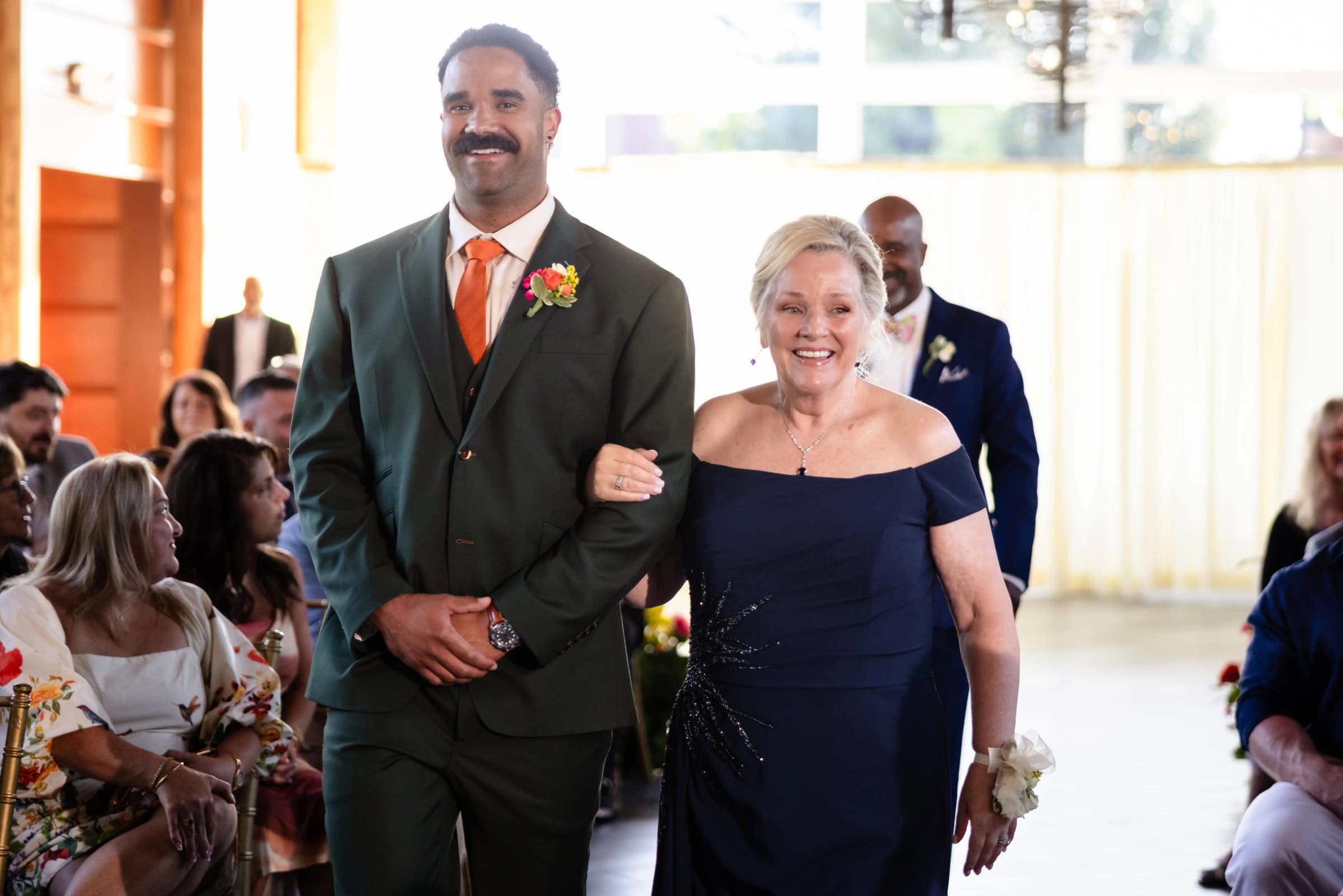 A man and woman walk arm-in-arm down the aisle during a wedding ceremony processional. &mdash; Wedding at Landmark Tavern at Stonehouse, Warren, NJ