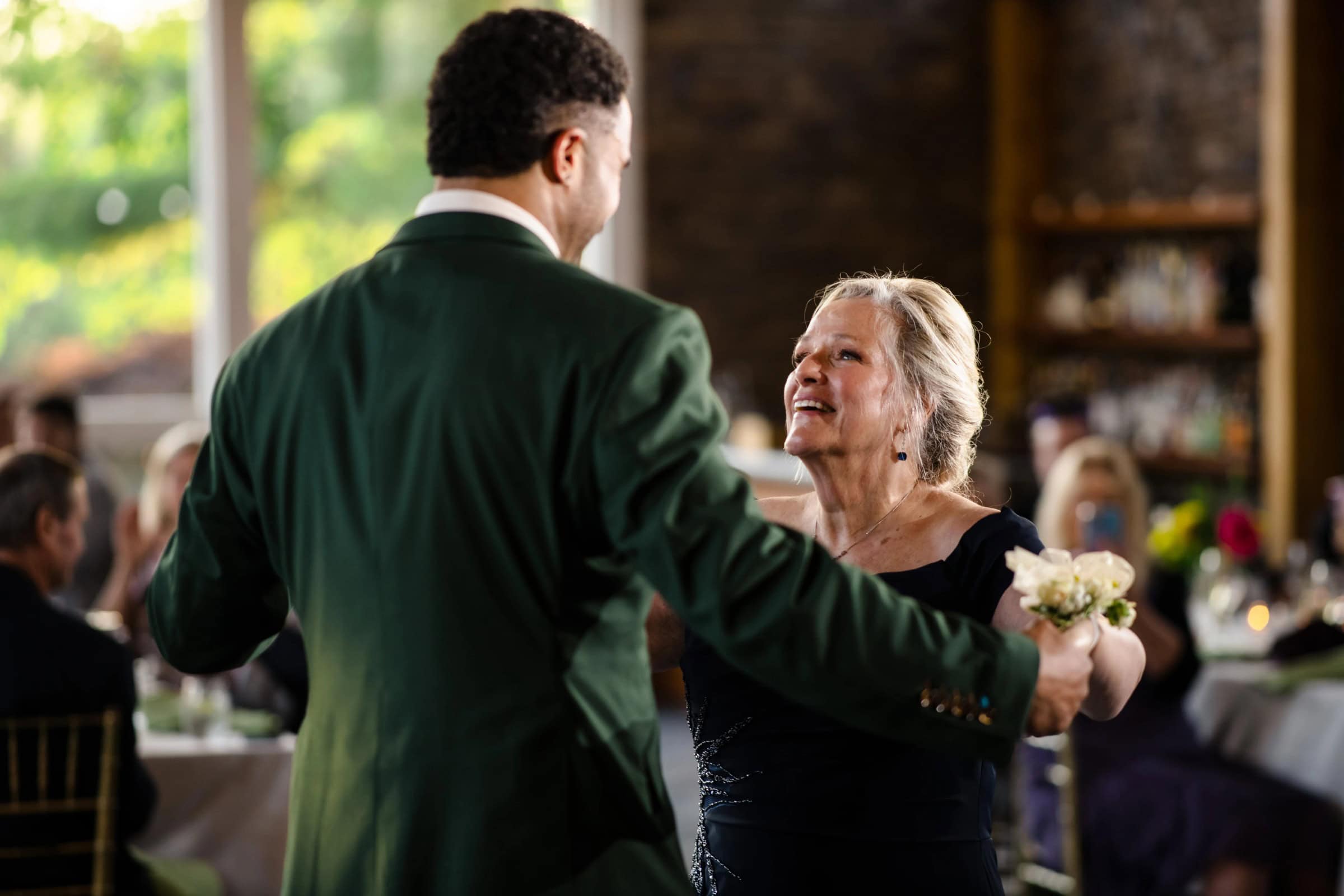 Older woman and man in green jacket dancing together at a reception, both smiling. &mdash; Wedding at Landmark Tavern at Stonehouse, Warren, NJ