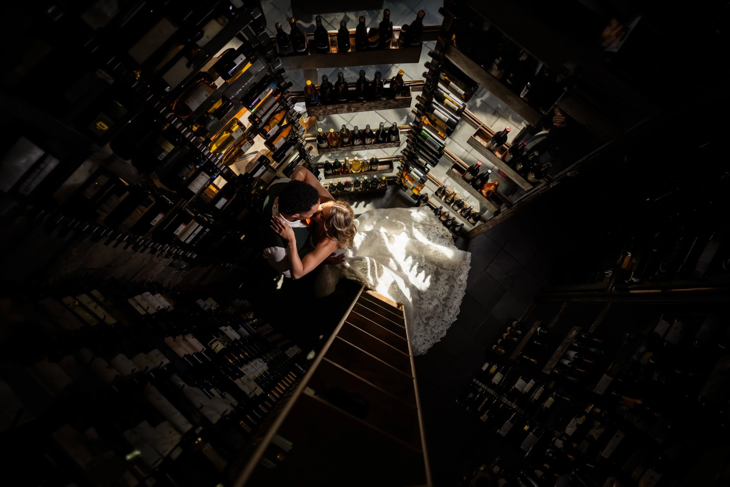 Person standing on a narrow ledge high above a city street at night, looking down at the illuminated urban landscape below. &mdash; Wedding at Landmark Tavern at Stonehouse, Warren, NJ