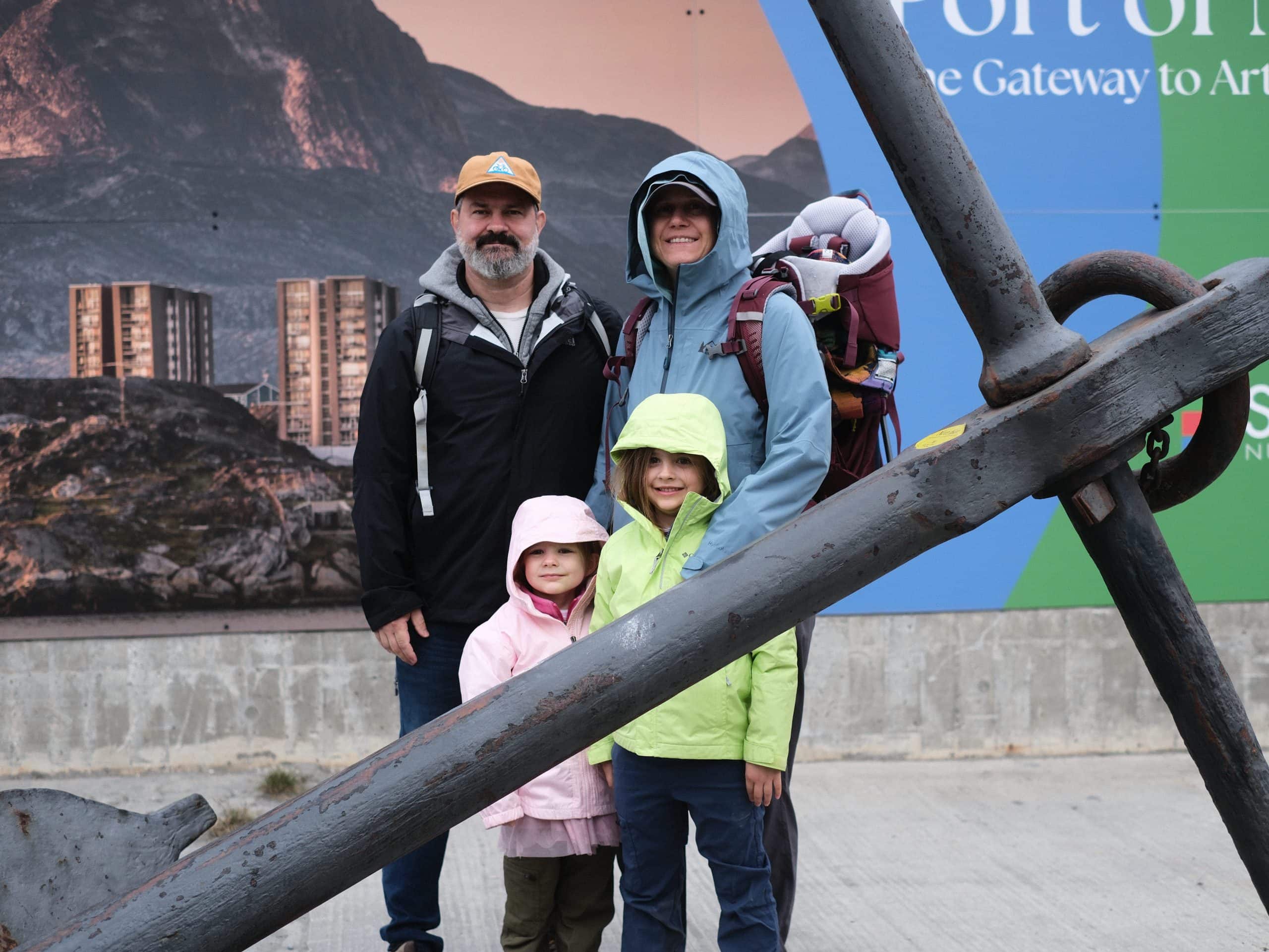 Steve and his family together beside a large anchor on their Greenland trip.
